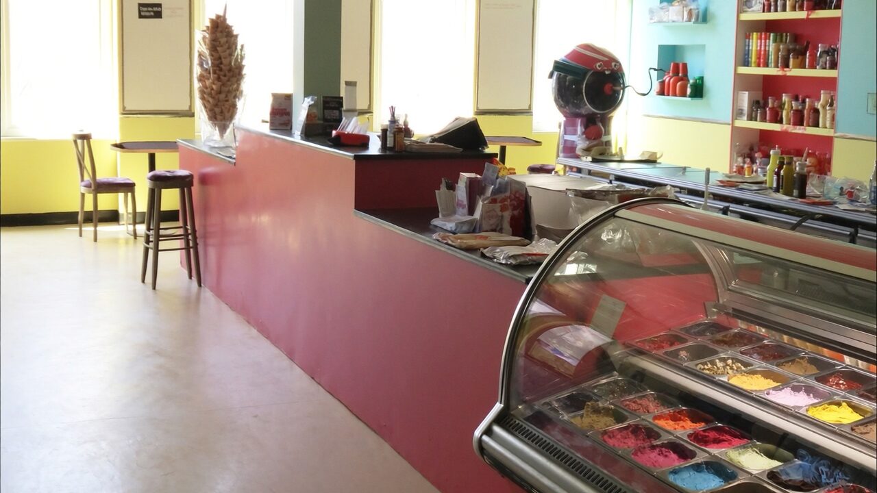Bright, colorful ice cream shop with a case full of flavors